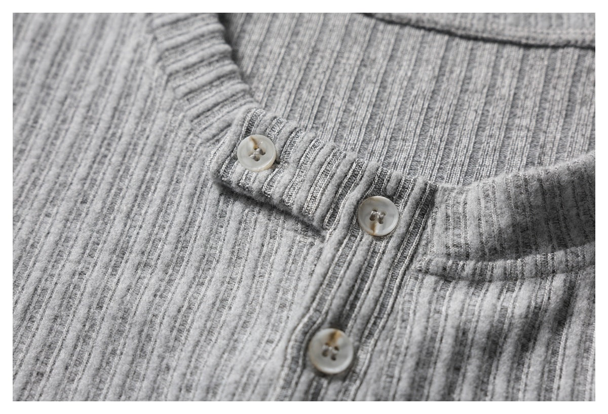 Close-up of the gray ribbed neckline and button fastening with light-colored buttons.