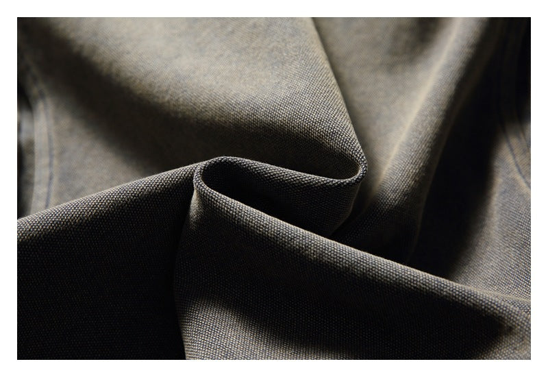 Close-up showing the fine woven texture and folds of mottled gray-olive fabric.