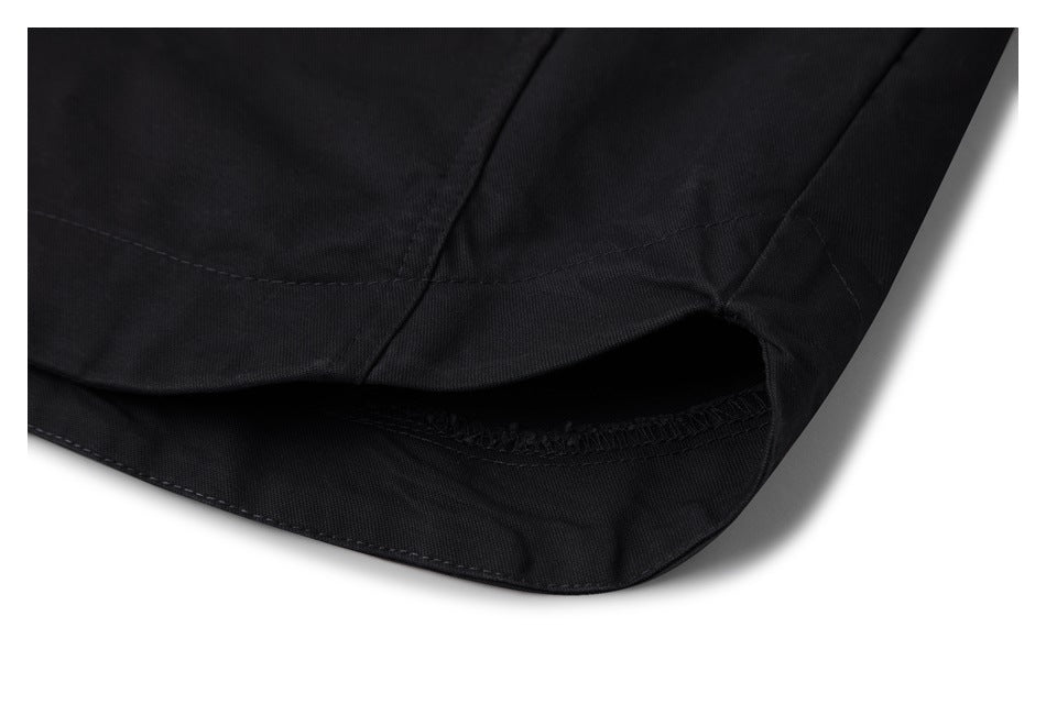 Close-up of a black garment hem opening with visible seam and overlock stitching.