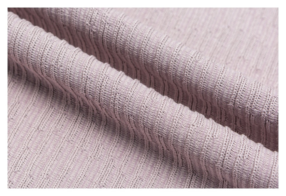 Close-up showing the raised ribbed texture of mauve knit fabric folded over itself.