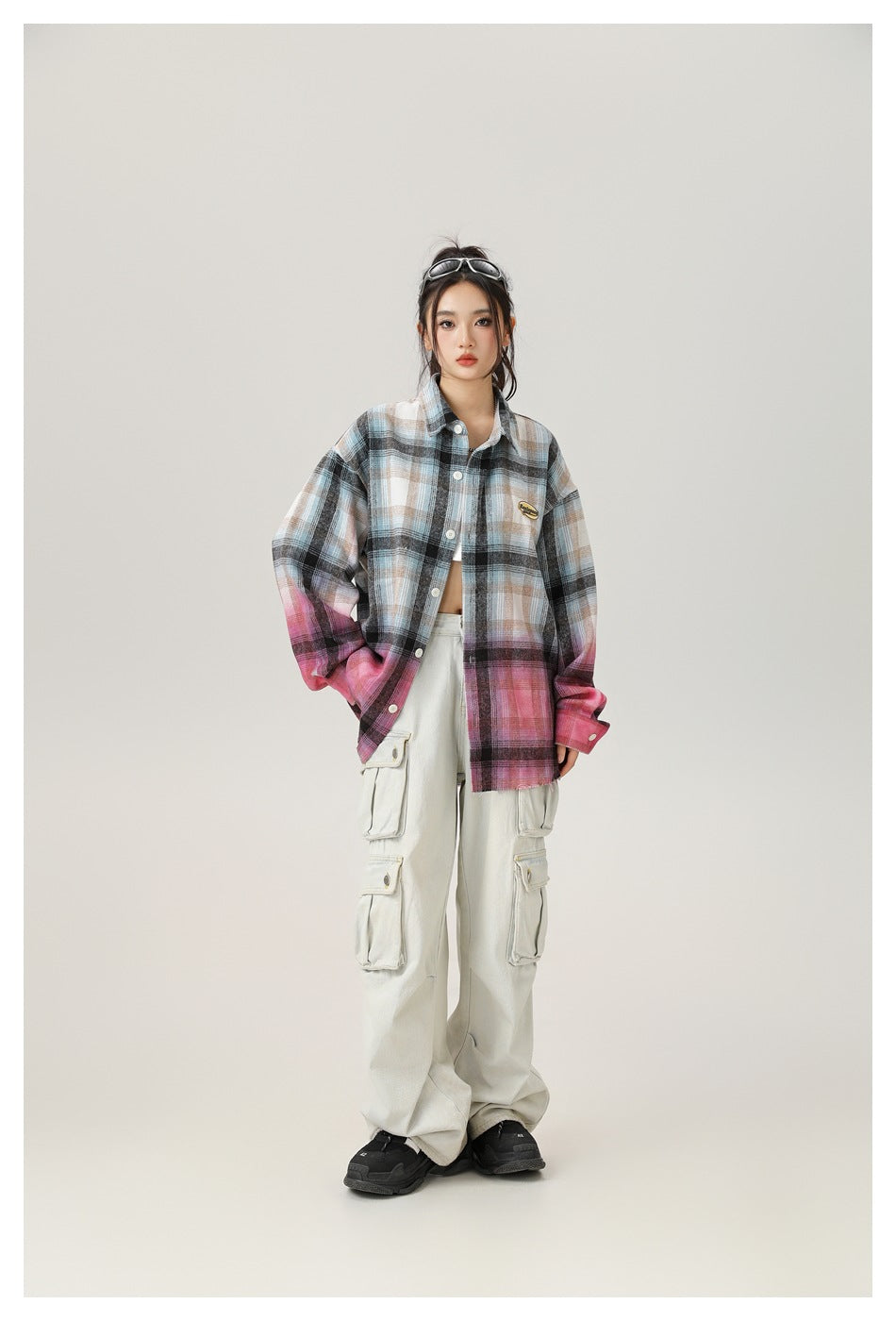 Model wearing the gradient plaid shirt open over a white top with light cargo pants