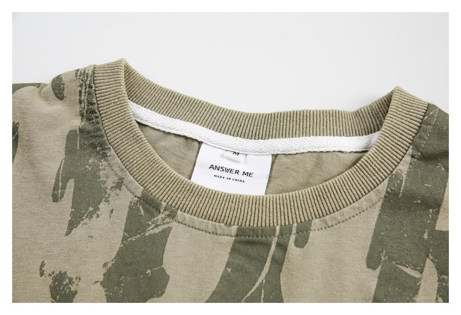 Close-up of a khaki camouflage T-shirt's ribbed crew neck, inner tape, and sewn label.