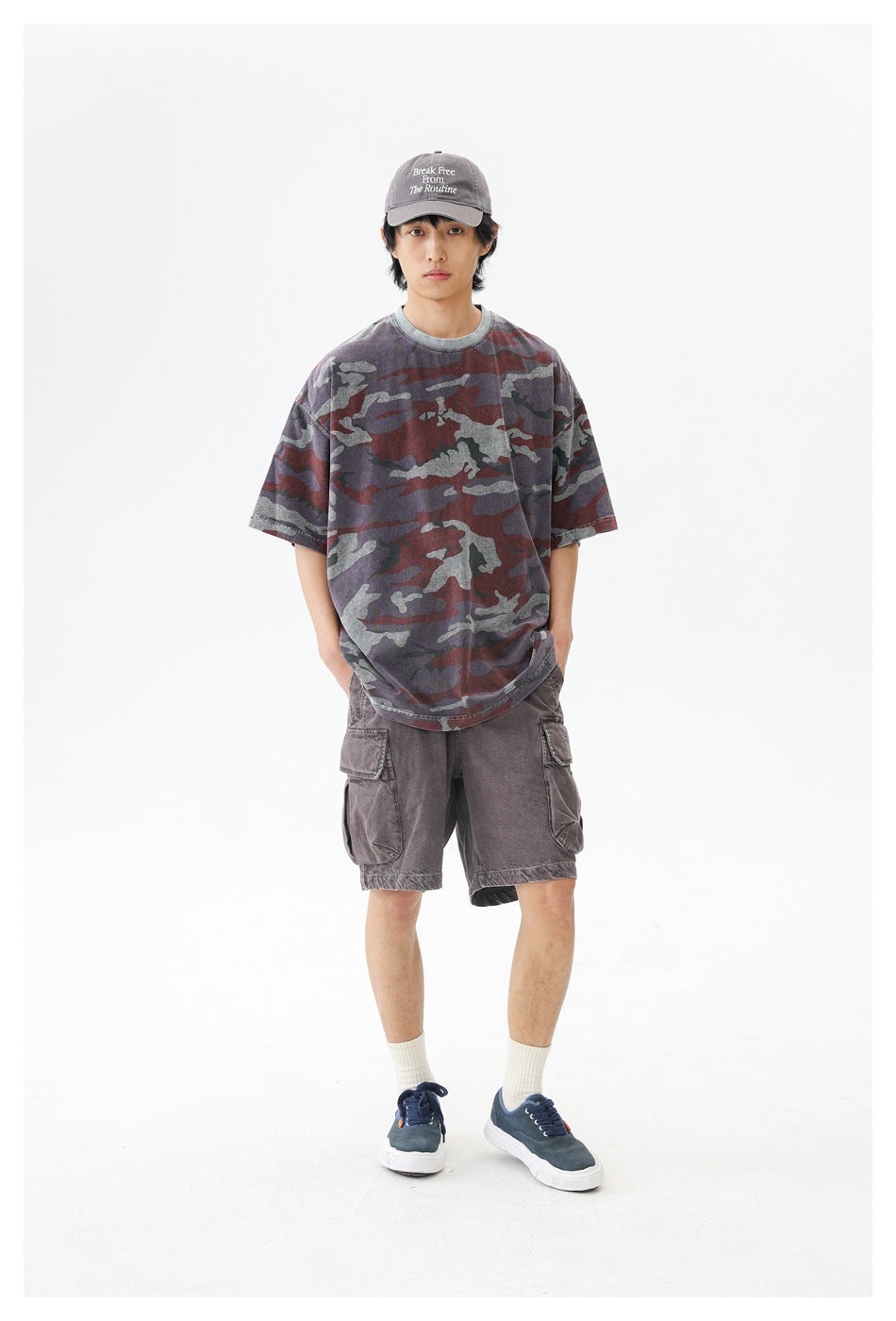 Model wearing an oversized burgundy, gray and charcoal camouflage T-shirt with gray cargo shorts.