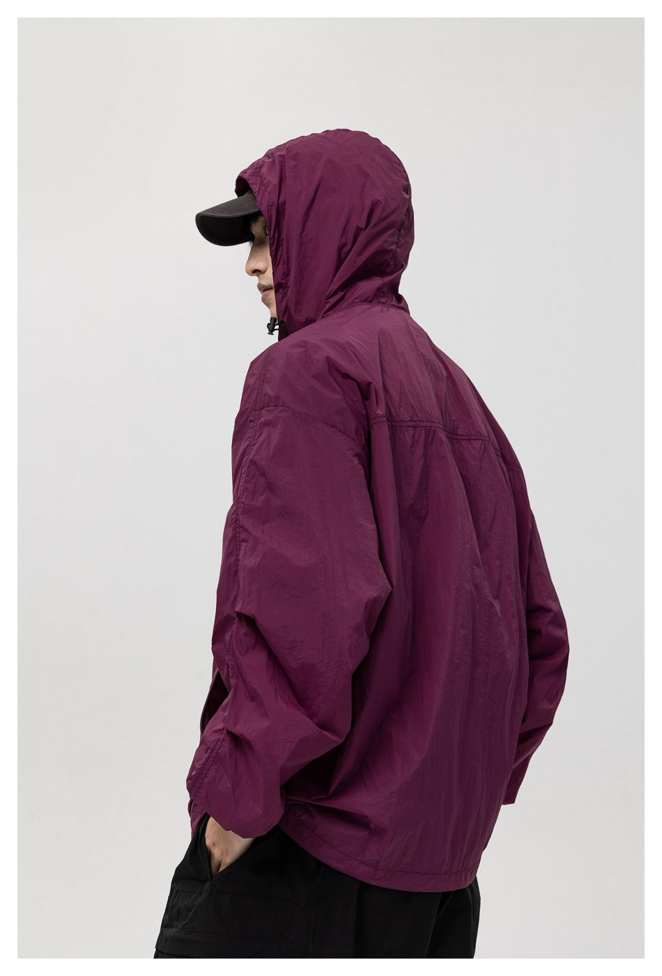 Side and rear view of a model wearing the plum hooded jacket, showing its back seams and hood.