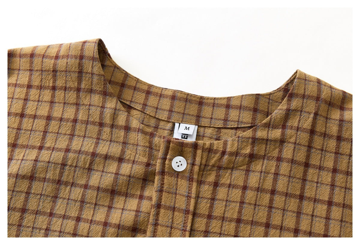 Close-up of a brown plaid shirt's neckline, white button, and sewn size label.