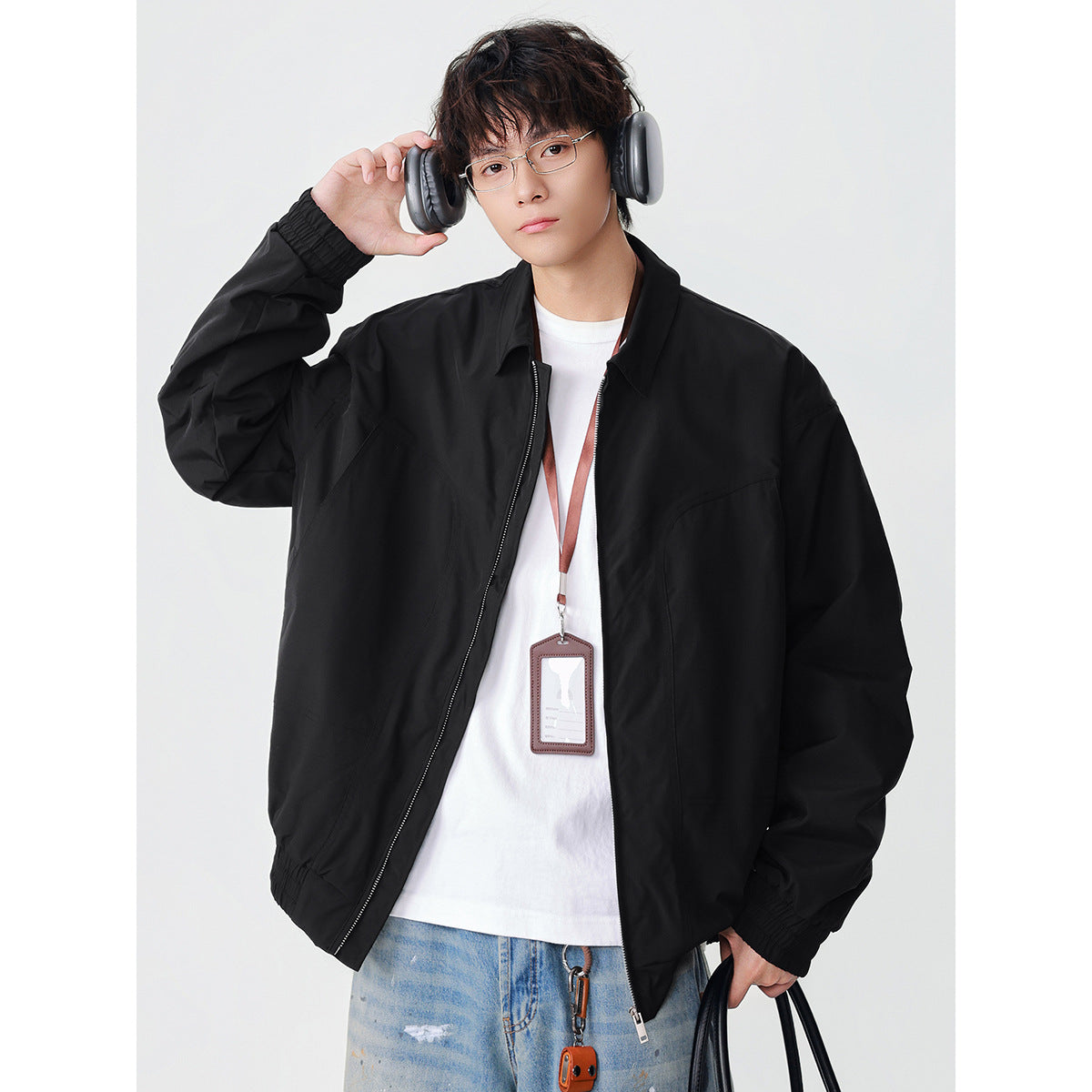 Model wearing a black zip jacket with a pointed collar, elastic cuffs and hem, and front pockets.