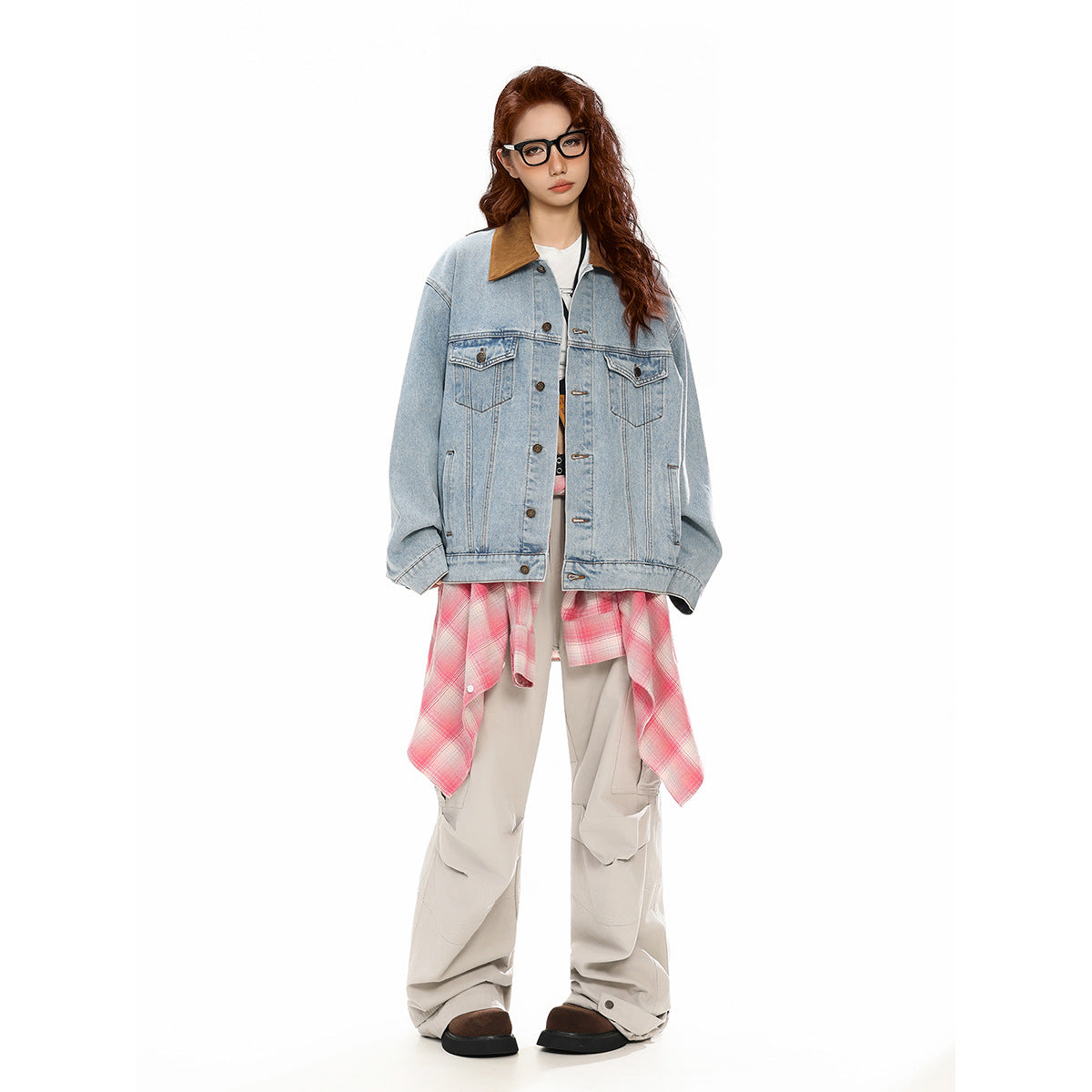 Full-length model wearing an oversized light-wash denim jacket with a brown collar, pink plaid shirt, and loose beige cargo