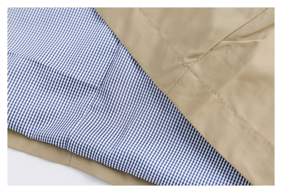 Close-up of beige coat fabric and seams beside blue-and-white patterned lining.