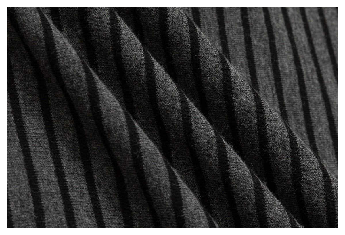 Macro view of charcoal-gray and black striped knit fabric gathered into soft folds.