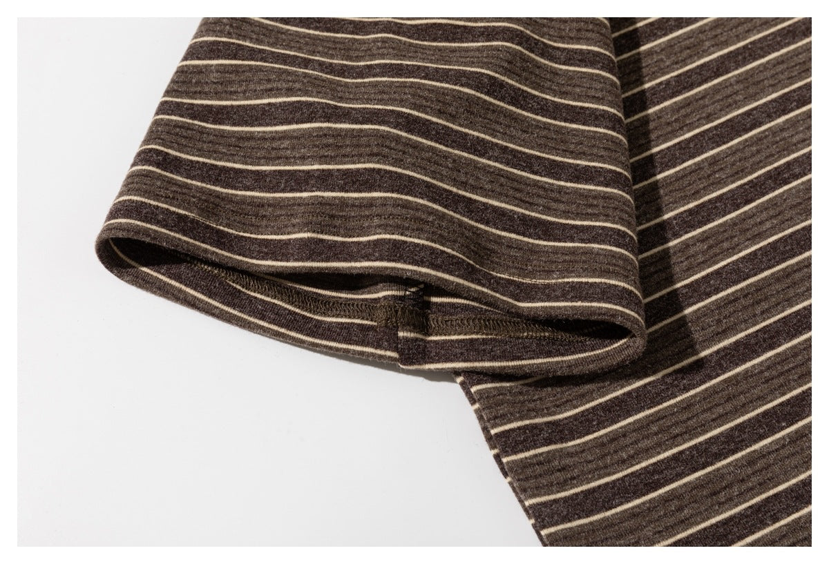Close-up of the sleeve hem on a dark brown shirt with thin cream stripes.