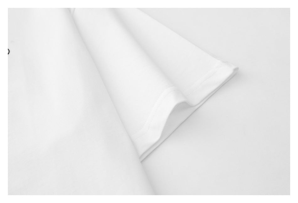 Close-up of the white T-shirt’s short sleeve, showing the cuff stitching and fabric.