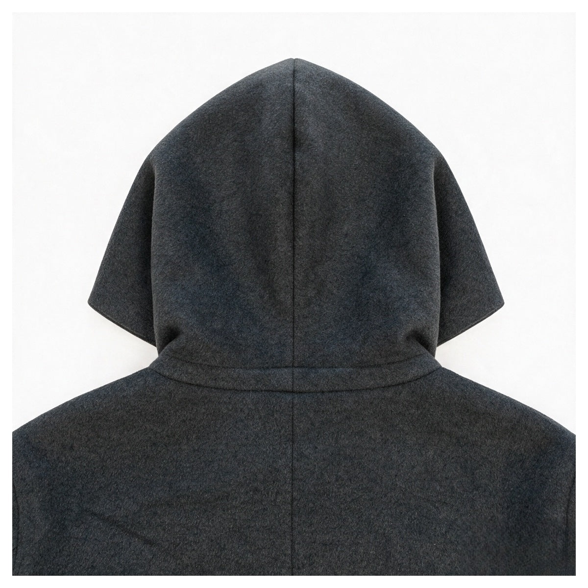 Close-up of the back of a charcoal gray jacket, showing its hood seam and upper back.