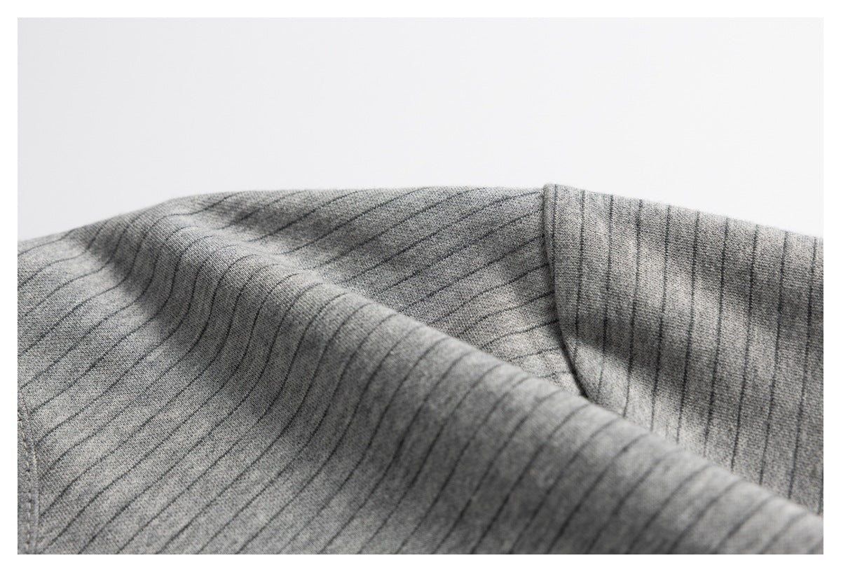 Close-up showing the gray top’s striped fabric and a stitched seam.