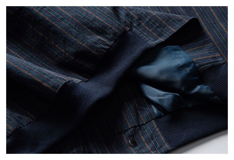 Close-up of a striped navy garment interior with dark ribbed trim, blue lining, and a snap fastener.