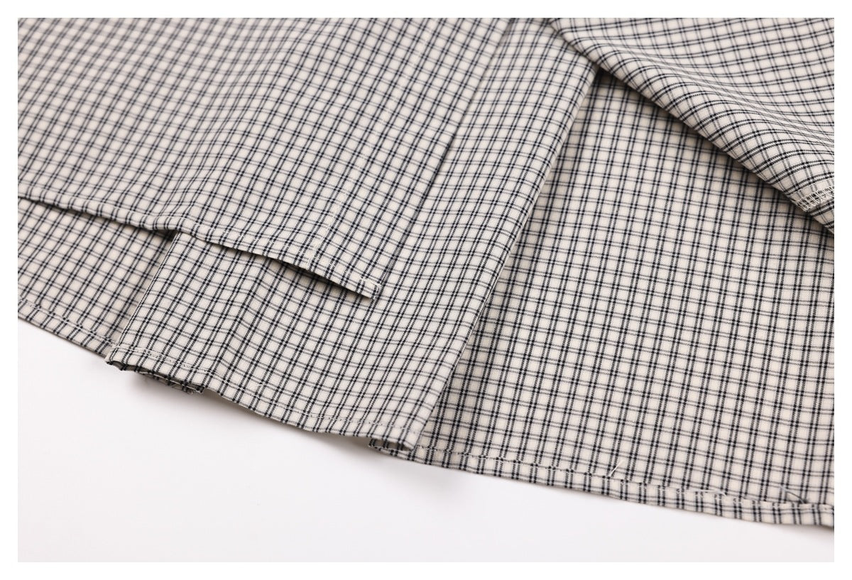 Close-up of the checked shirt's overlapping hem and stitched edge.