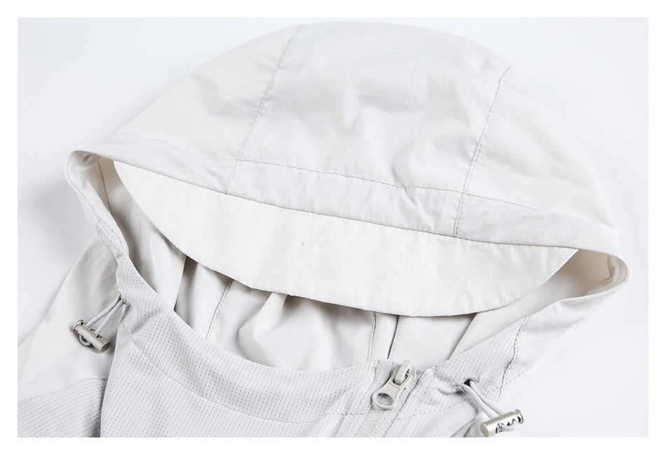 Close-up of a white jacket hood, adjustable drawcord toggles, and front zipper.