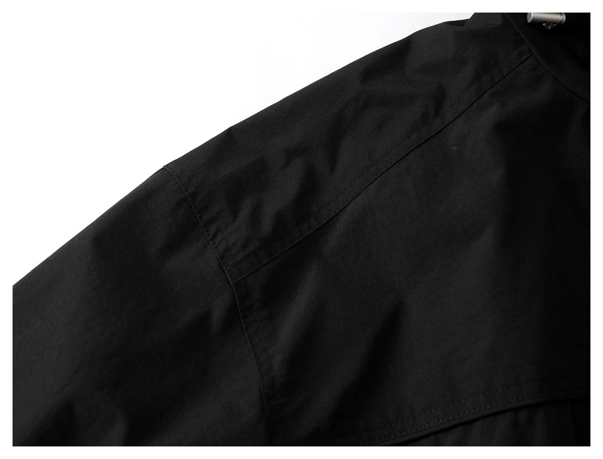 Close-up of the black jacket's sleeve and stitched shoulder seam.