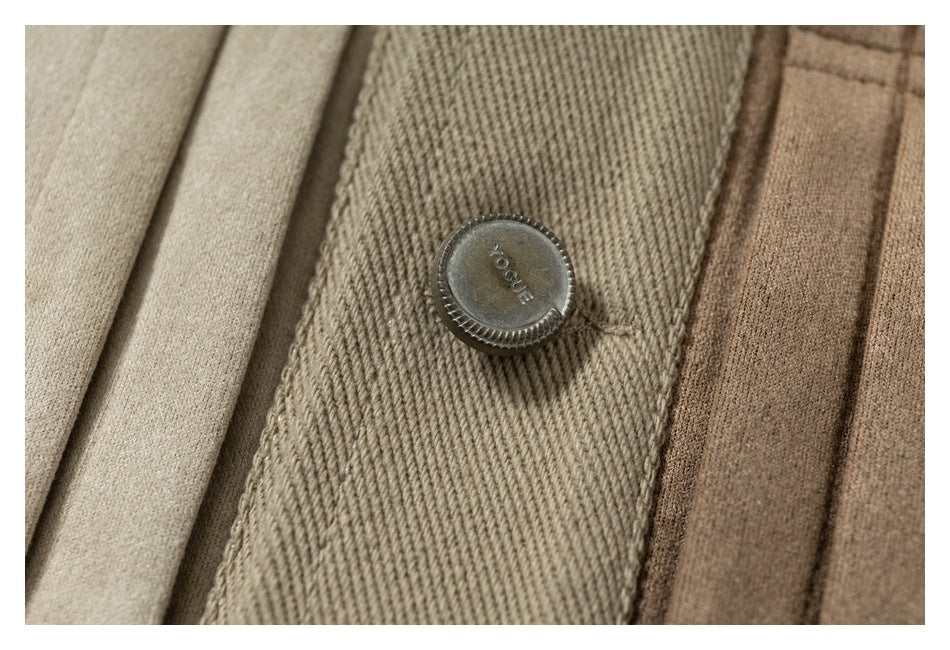 Close-up of a dark metal button stamped “YOGUE” on a textured brown garment placket.
