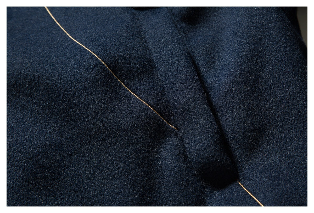 Close-up of navy jacket fabric and a seam edged with tan piping.