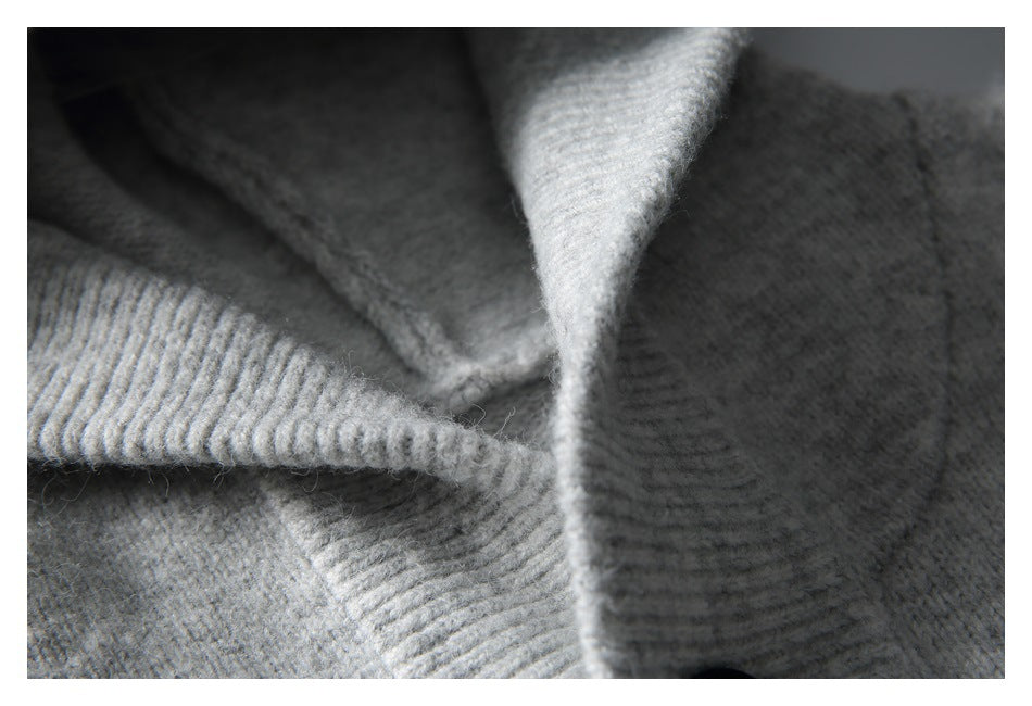Macro view of gray knit fabric and ribbed hood edging with visible stitching.