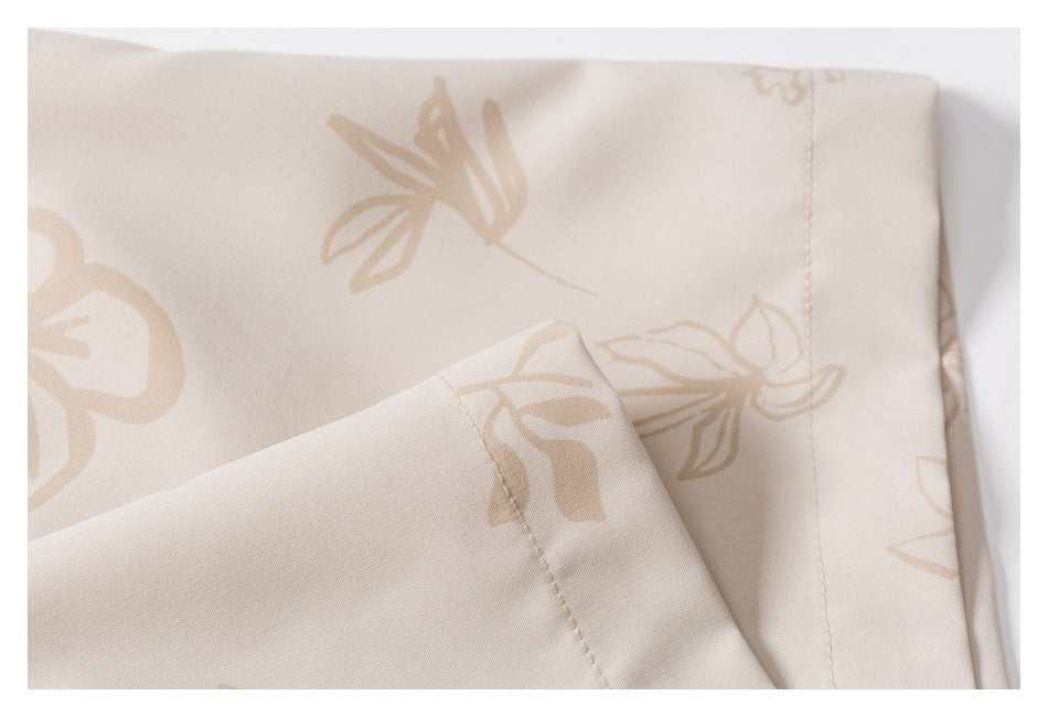 Close-up of cream floral-print fabric folded to show a stitched seam and hem.