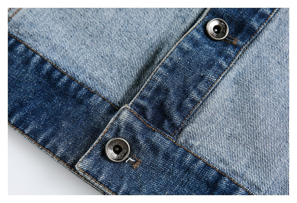 Close-up of a dark denim waistband fastening with two metal buttons and contrasting stitching.