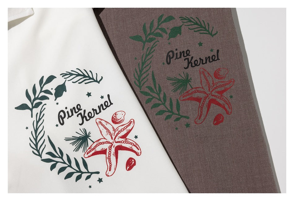 Close-up of green and red sea-themed graphics printed on white and taupe shirt fabric.