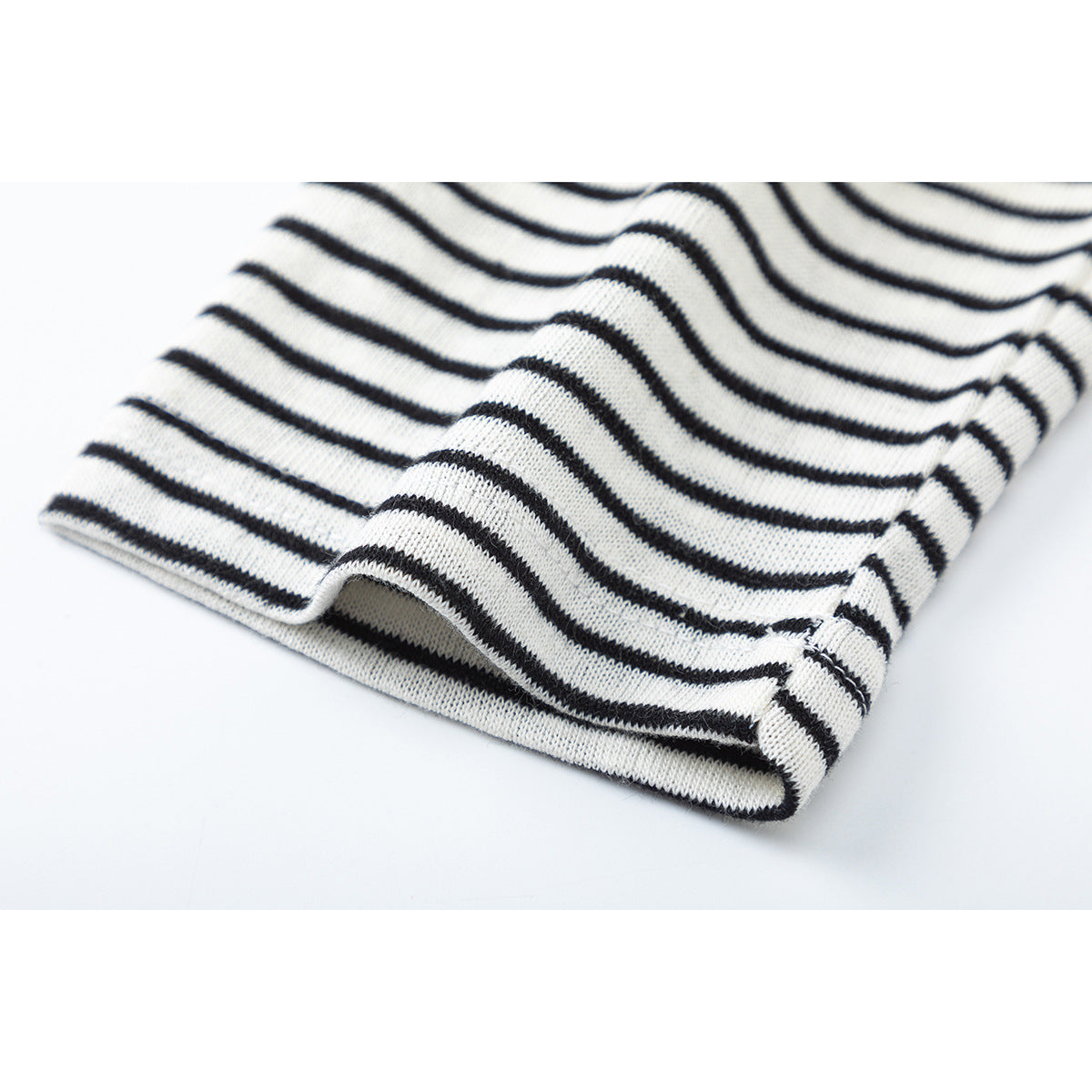 Close-up of the folded hem of a black-and-white horizontally striped shirt.