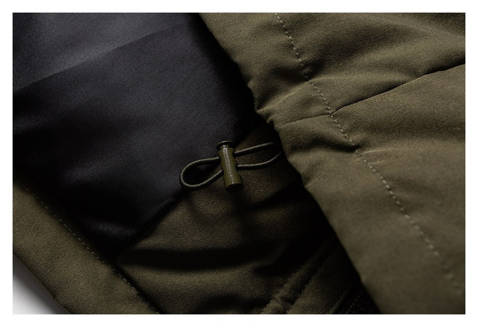 Close-up of an olive garment's adjustable drawcord toggle beside a dark lining panel.