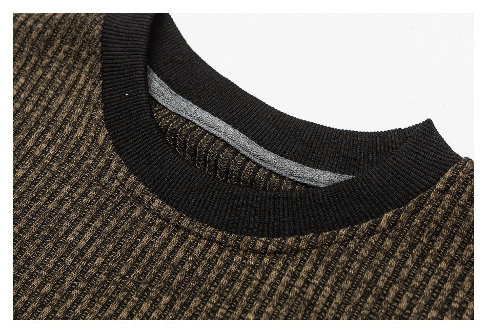 Close-up of the brown textured shirt's black ribbed crewneck collar and inner seam.
