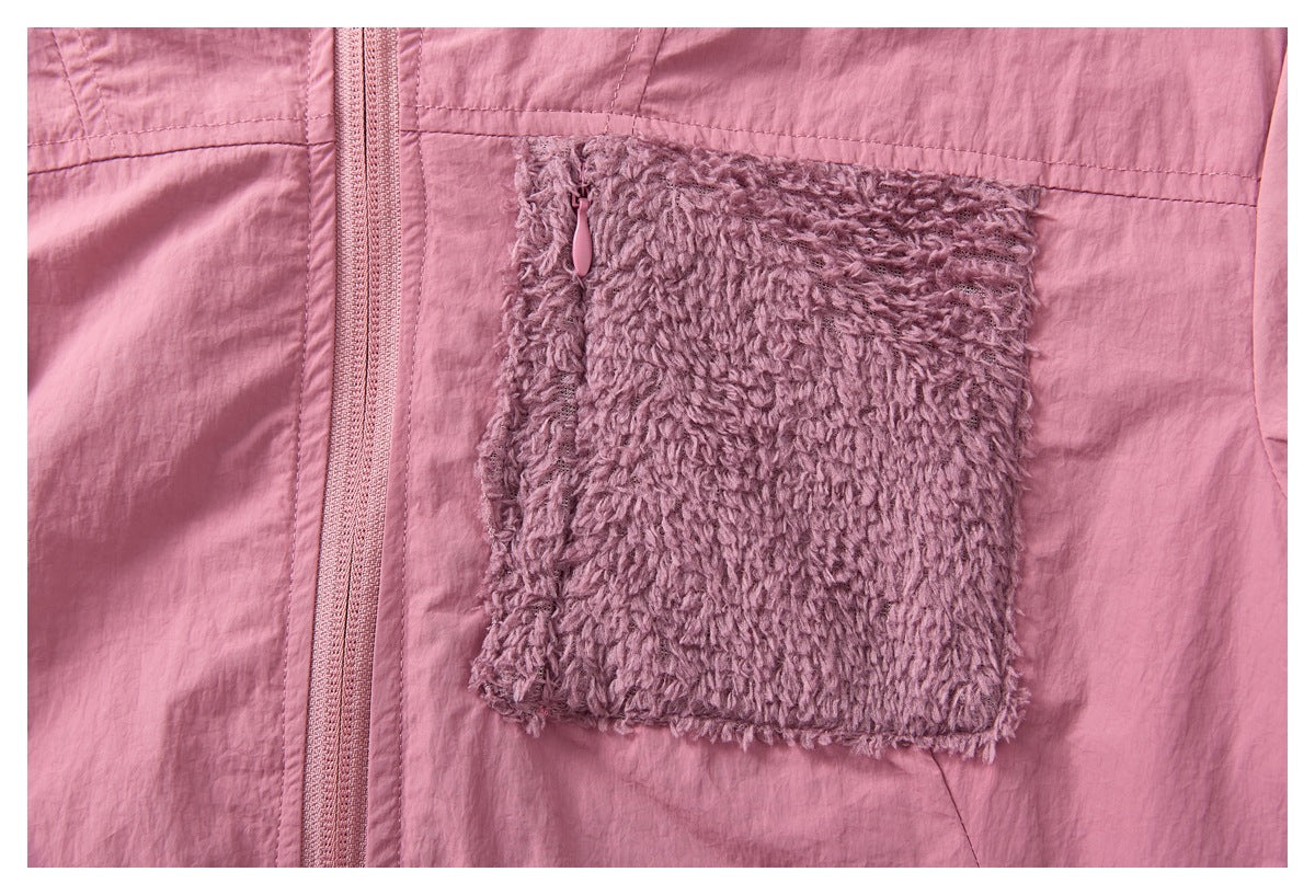 Close-up of the jacket's fuzzy mauve chest pocket beside the pink front zipper.