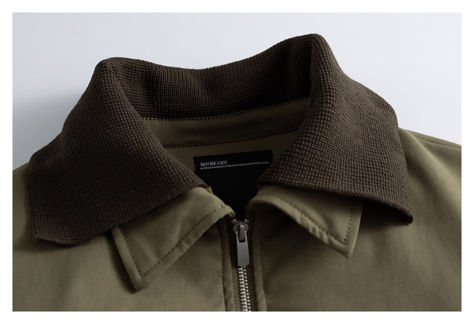 Close-up of an olive jacket's dark brown textured collar and front zipper.