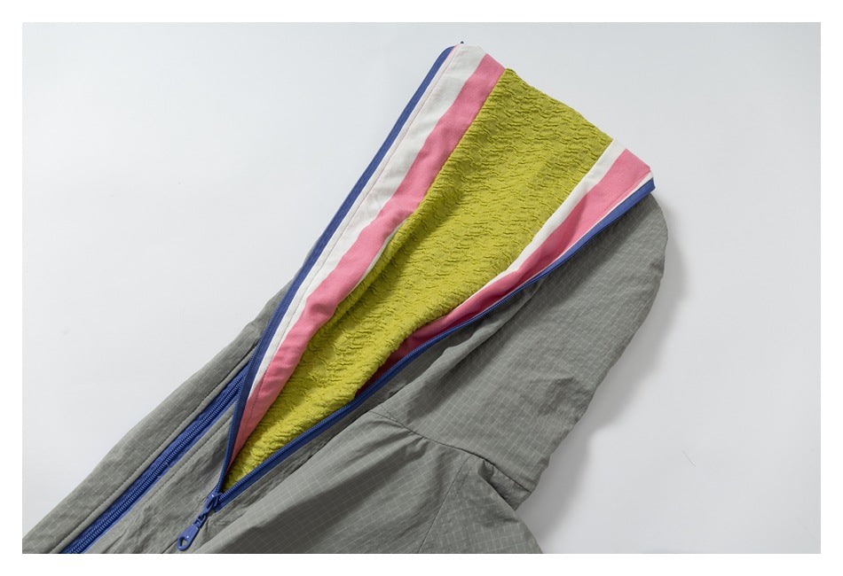 Close-up of the jacket's open hood, showing lime, pink and white lining with blue zipper trim.