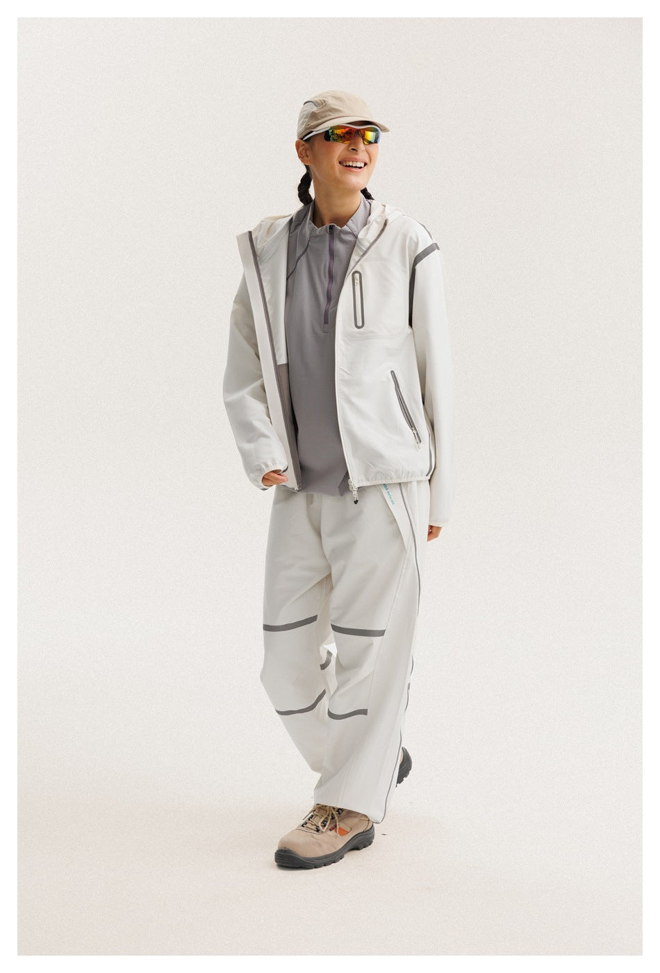 Model wearing an open white hooded jacket over a gray top with matching gray-trimmed pants.