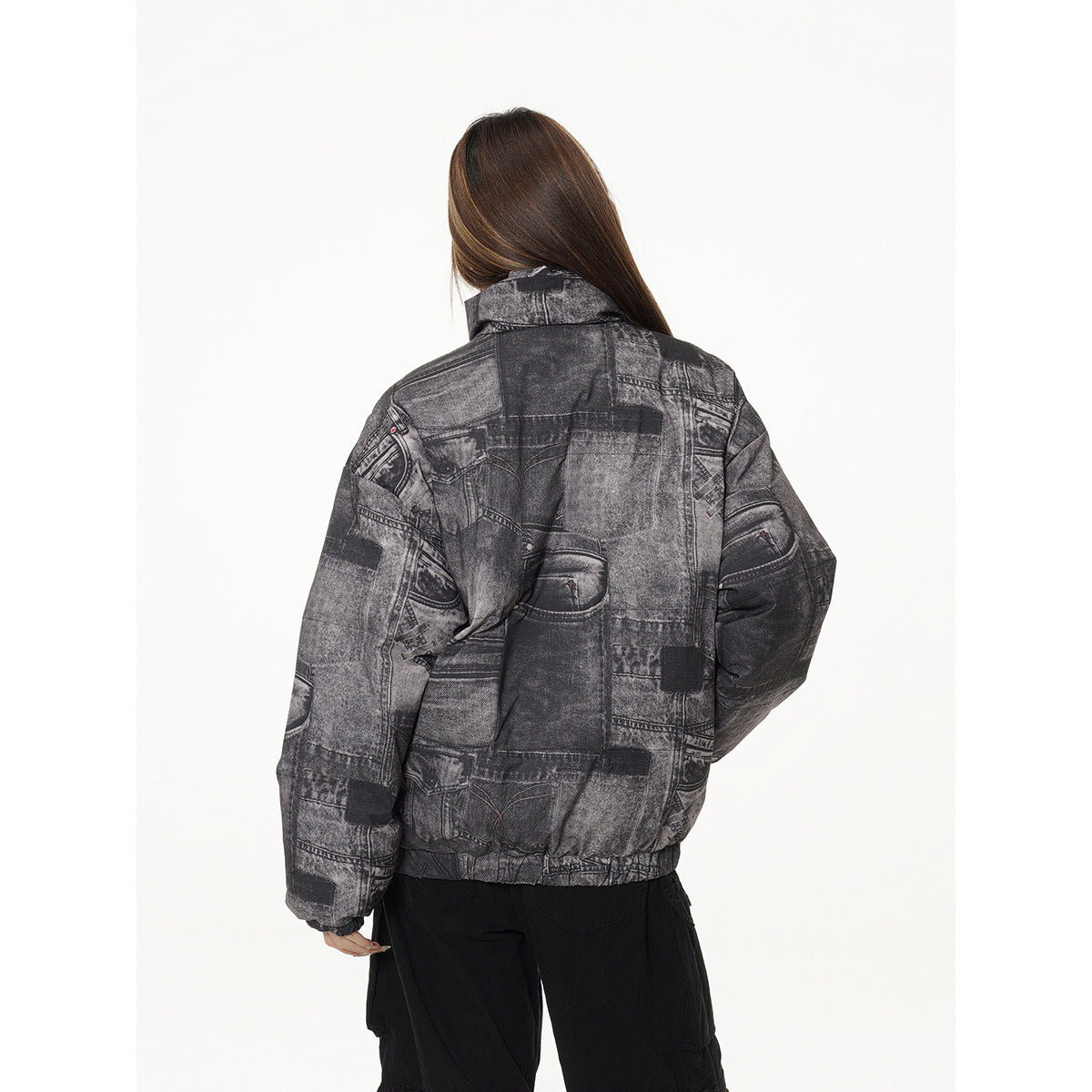 Back view of a model wearing a charcoal patchwork-print padded jacket with an elastic hem.