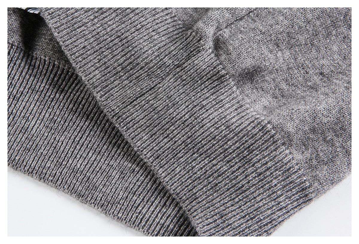 Close-up of the gray knit garment's ribbed hem and adjoining knit panels.