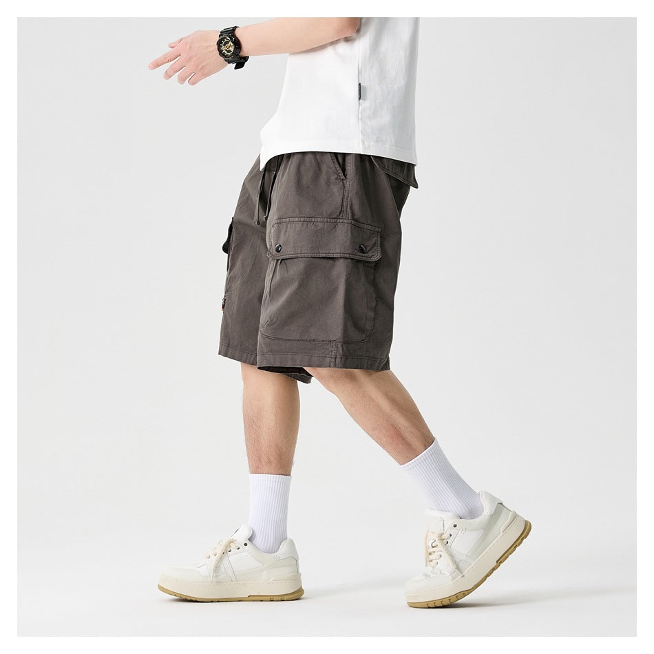 Side view of a model wearing charcoal gray cargo shorts with a large flap pocket.