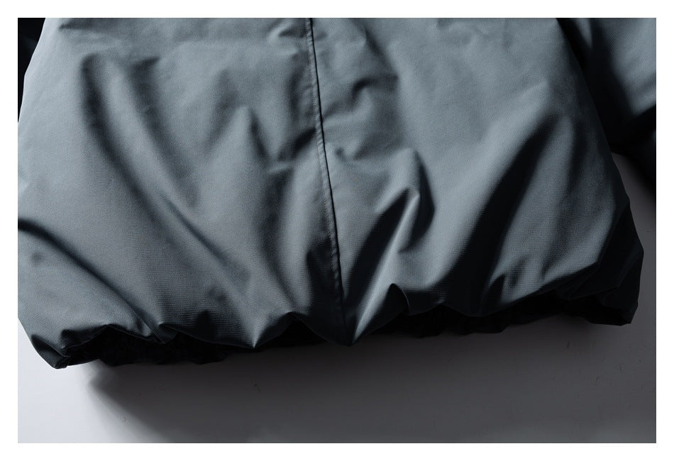Close-up of the slate-gray jacket's back panel, center seam, and gathered lower hem.