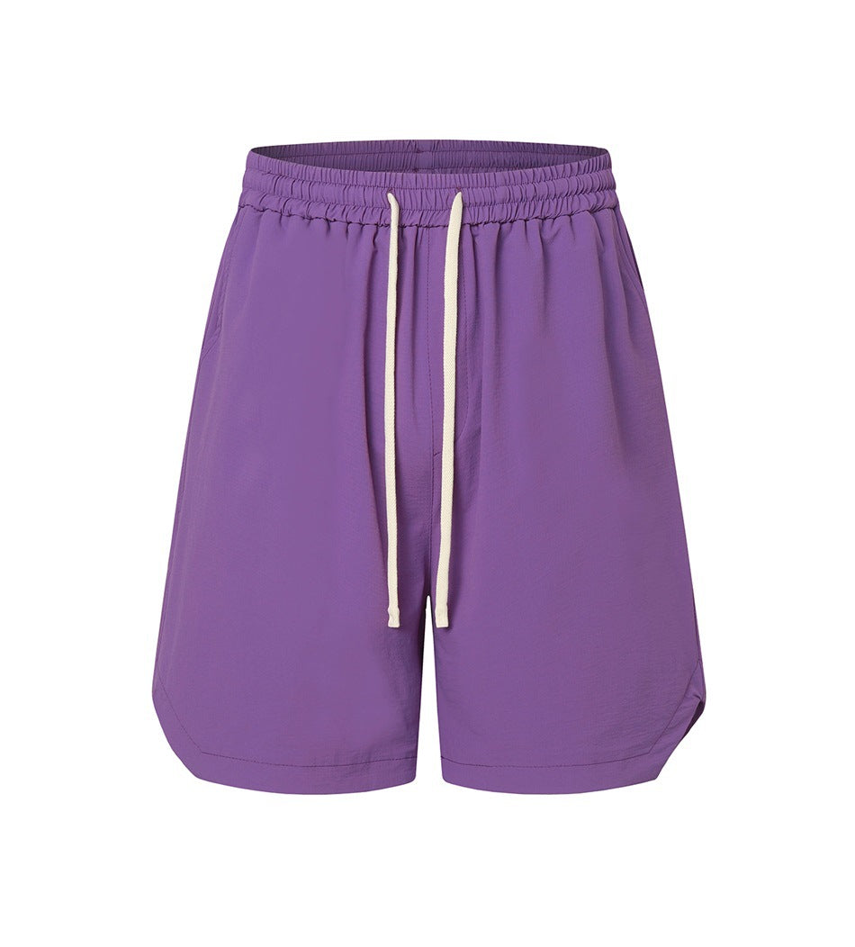 Purple drawstring shorts with elastic waistband and curved side hems, front view on white background