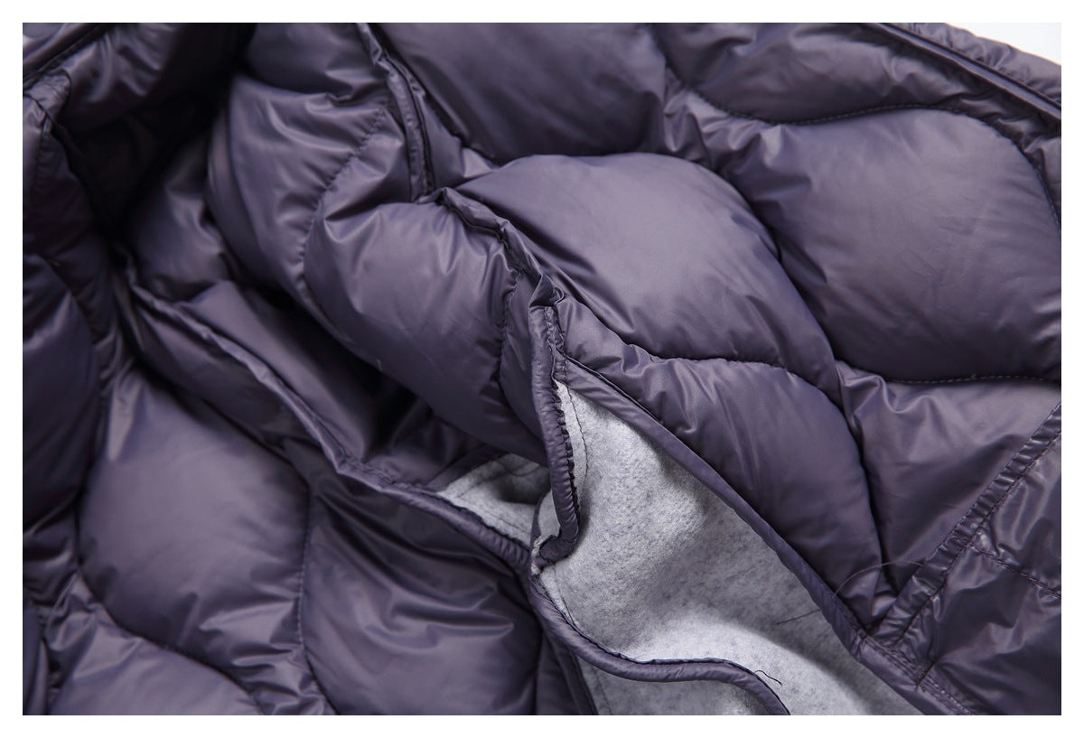 Close-up of dark purple quilted lining folded back to reveal the light gray garment interior.