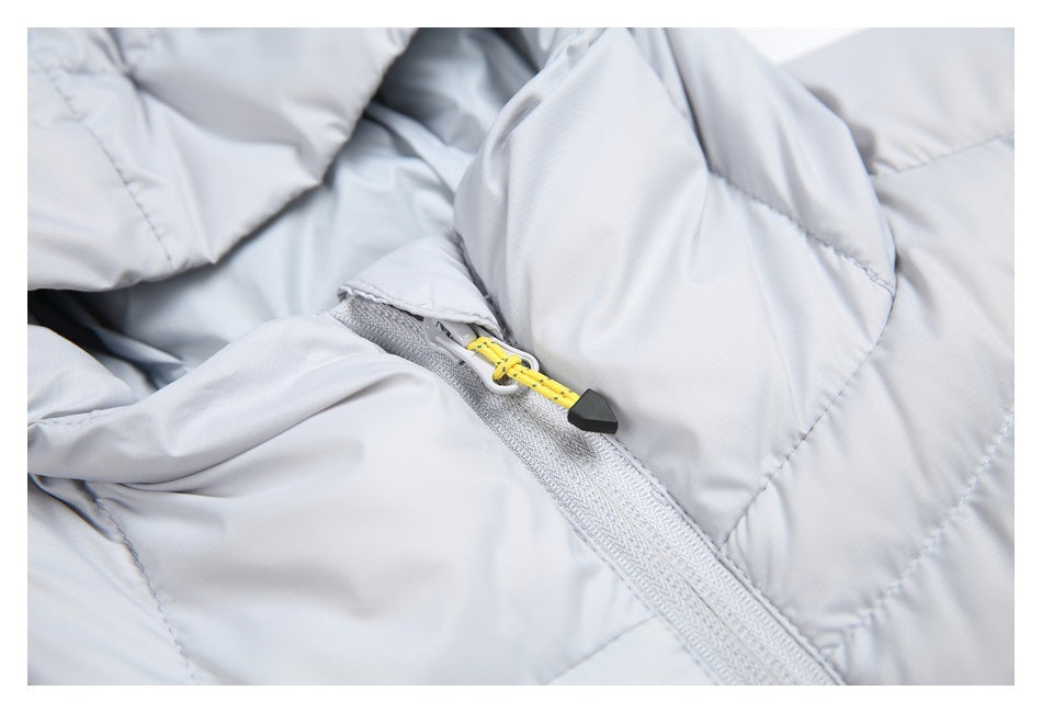 Close-up of a light gray jacket zipper with a bright yellow cord pull and black toggle.