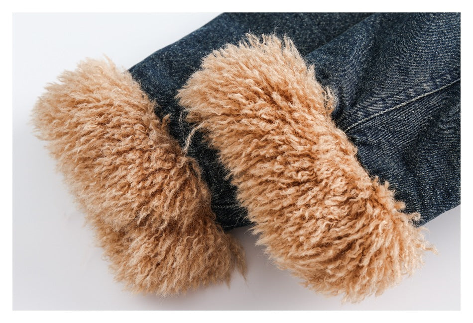 Close-up of thick tan fuzzy cuffs against the sleeves of a dark denim jacket.