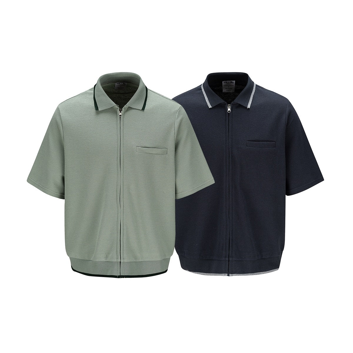 Two short-sleeve textured zip shirts shown from the front: sage green and dark navy, each with a collar and chest pocket.