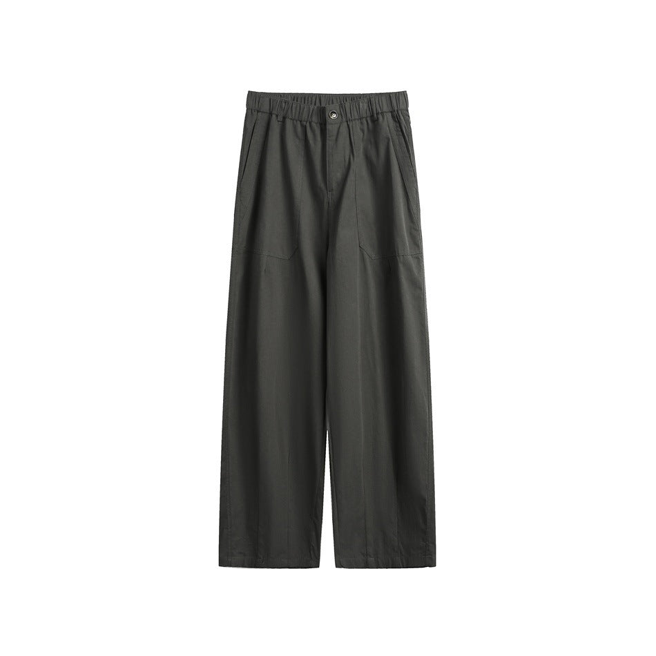 Front view of dark charcoal wide-leg trousers with an elastic waistband, button closure and large front pockets.