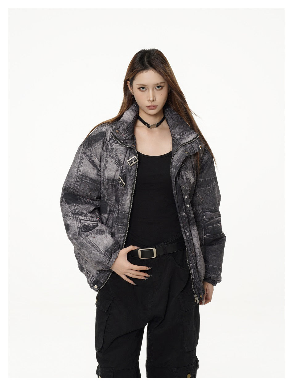 Front view of a model wearing an open charcoal patchwork-print padded jacket with buckle details and a high collar.