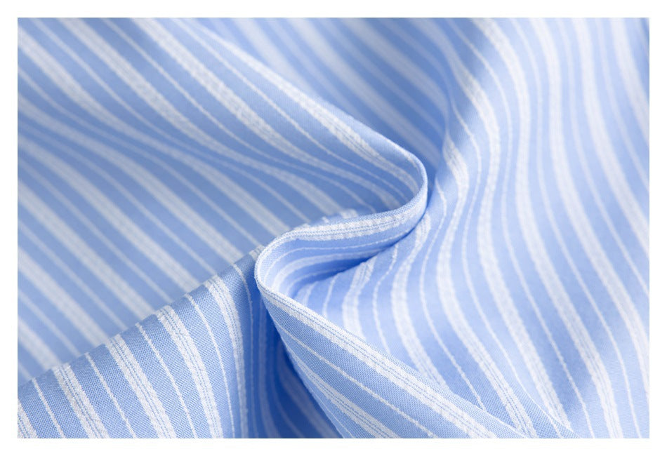 Close-up of light blue fabric with narrow white stripes, draped to show its texture.