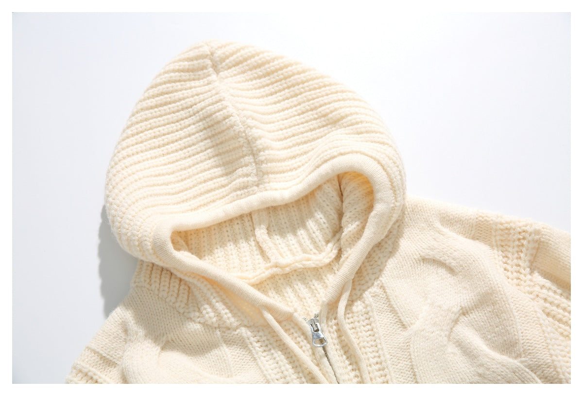 Close-up of the cream sweater's ribbed hood, drawstrings, and silver front zipper.