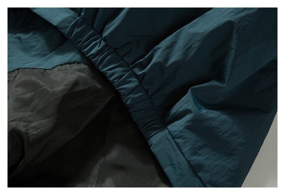 Close-up of gathered dark teal fabric beside a dark lining.