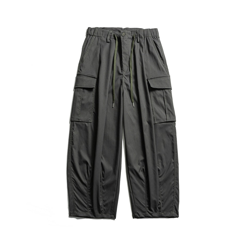 Dark gray wide-leg cargo pants with elastic drawstring waist and large flap pockets, front view