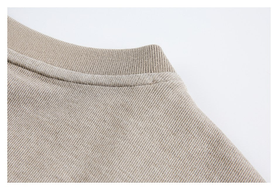 Close-up of the ribbed neckline and shoulder area of a beige knit garment.